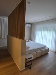a bedroom with a bed and a large window at EMERALD Suites Cervia in Cervia