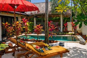 a resort with a pool with a table and an umbrella at Hakuna Matata Bali Villas in Uluwatu