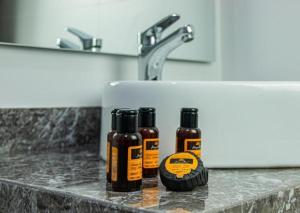 three bottles of essential oils sitting on a counter next to a sink at Marchica Hotel in Nador +40 photos