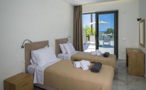 a hotel room with two beds with towels on them at Phoenix Coastal Heaven in Loutro
