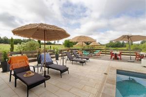 a patio with chairs and umbrellas next to a pool at Chambres D'hôtes Bien-être Simple in Belvès