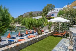 a resort with a pool and chairs and an umbrella at Phoenix Coastal Heaven in Loutro