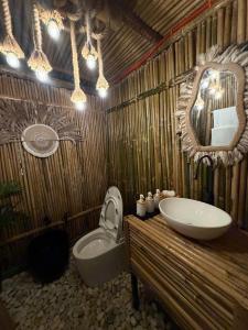 a bathroom with a sink and a toilet and a mirror at Cocoon De Coron in Coron
