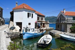 two boats are docked in front of a building at Apartman UNA in Bjelila