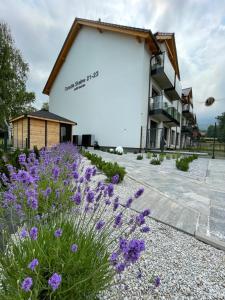 a building with purple flowers in front of it at Apartamenty Skalny Loft in Karpacz