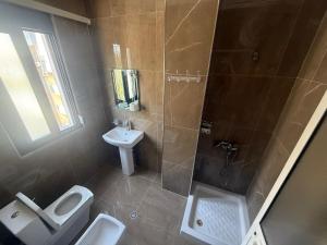 a bathroom with a shower and a toilet and a sink at Hotel Italia in Golem