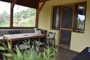 a wooden table and chairs on a patio with a couch at Aranyos Downhill in Nagymaros