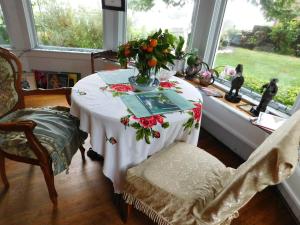 a table in a room with a vase of flowers on it at Cliff Crest Inn in Santa Cruz