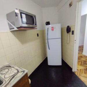 a kitchen with a white refrigerator and a microwave at alma in Buenos Aires