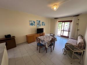 a living room with a table and a couch at Casa vacanze Heidi con piscina in Marina di Bibbona
