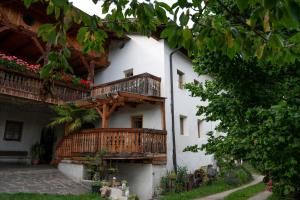 ein weißes Gebäude mit hölzernen Balkonen in der Unterkunft Saxöler Brixen in Brixen