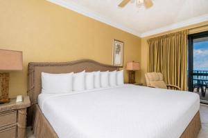 a bedroom with a large bed and a balcony at Phoenix VI 61509 in Orange Beach