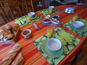 a table with plates of food and bread on it at Chambre d'hôtes les Rosiers in La Flèche +4 photos