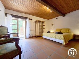 a bedroom with a bed and a wooden ceiling at Brasserie du Goutté in Roquefort