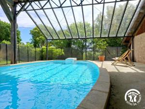 a swimming pool with a glass canopy over it at Brasserie du Goutté in Roquefort