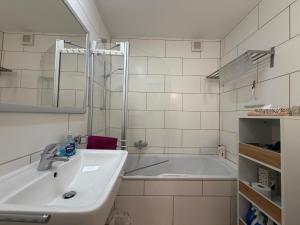 a bathroom with a sink and a bath tub at Casa Constantinus in Unteruhldingen +29 photos