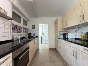 a large kitchen with black counter tops and appliances at Casa Constantinus in Unteruhldingen