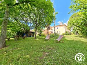 two chairs sitting in the grass in a yard at Brasserie du Goutté in Roquefort +10 photos