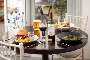 a table with two plates of food and a bottle of wine at Best Western Red Lion Hotel in Salisbury