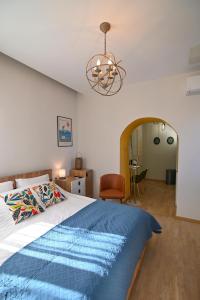 a bedroom with a bed and a chandelier at Karivaliko in Vrontádos