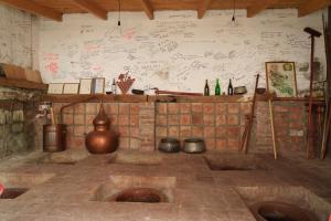a room with a brick wall with drawings on the wall at Milorava's Guest House & Wine Cellar in Telavi