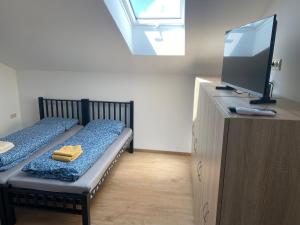 a small room with two beds and a television at 3 Elementy in Čachtice