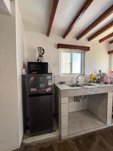 a kitchen with a sink and a refrigerator at Mida creek front one bedroom in Watamu
