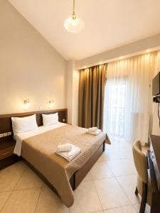 a bedroom with a bed with two towels on it at Kladis Club Holidays in Skala Potamias