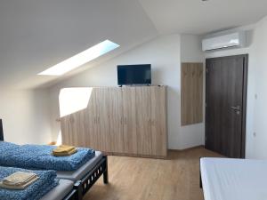 a bedroom with two beds and a tv on a cabinet at 3 Elementy in Čachtice