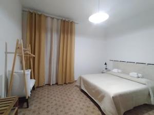 a bedroom with a bed and a window with curtains at B&B benallonga in Paulilatino