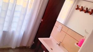 a bathroom with a sink and a mirror at "ATARDECER" Departamento a pocos minutos de termas in Chajarí