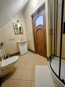 a bathroom with a toilet and a sink and a door at Willa WiK in Rewal +45 photos