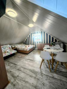 a room with two beds and a table and chairs at Willa WiK in Rewal