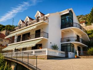a white house with a balcony and a bridge at Villa SeaView Panorama in Risan
