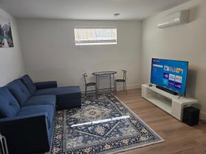 ein Wohnzimmer mit einer blauen Couch und einem Flachbildfernseher in der Unterkunft Light House in Riverview