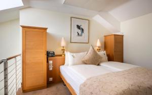 a hotel room with a bed and two lamps at GAIA Hotel Basel - the sustainable 4 star hotel in Basel +102 photos