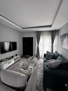 a living room with two couches and a flat screen tv at MAITA Apartments - Silverest, Lusaka in Chongwe