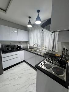 a kitchen with white cabinets and a stove top oven at MAITA Apartments - Silverest, Lusaka in Chongwe