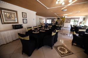 a dining room with black tables and black chairs at Ecotel Southgate in Southgate