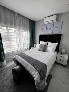a bedroom with a large bed and a window at MAITA Apartments - Silverest, Lusaka in Chongwe