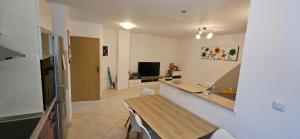 a kitchen and dining room with a table and a television at Luxury Flat with Heated Pool & Jacuzzi in Rijeka