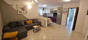 a living room with a couch and a kitchen at Luxury Flat with Heated Pool & Jacuzzi in Rijeka