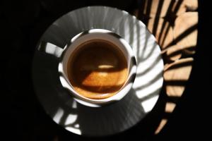a cup of coffee on a plate on a table at Villa Monet in Castiglione di Ravenna