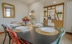 a black table with chairs and plates and flowers on it at La petite maison dans lusigny in Lusigny-sur-Barse +22 photos
