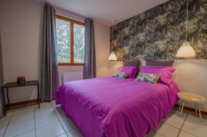 a bedroom with a purple bed with a purple blanket at La petite maison dans lusigny in Lusigny-sur-Barse