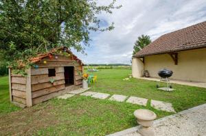 a dog house with a grill in a yard at La petite maison dans lusigny in Lusigny-sur-Barse