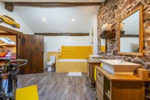 a bathroom with two sinks and a stone wall at Sarahandia in Aldudes +53 photos