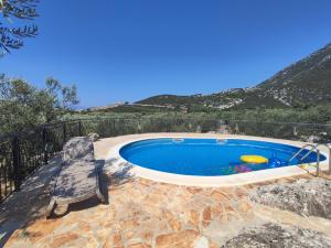 a swimming pool with a bench and a chair at Villa Lucija in Ploče