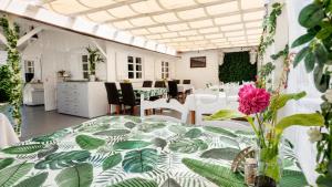 a white room with a table with a flower in a vase at Mielenko Domki Wakacyjny Raj in Mielenko