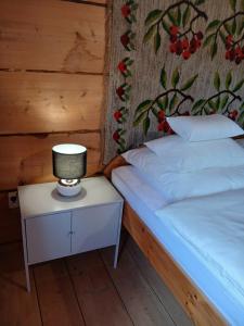 a bedroom with a bed and a lamp on a night stand at Bauernhaus in Dzianisz +7 photos